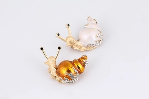Macro view of cute snail brooches featuring vibrant enamel finish and sparkling rhinestones