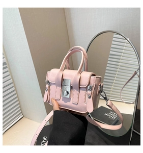 Détail du mini sac bandoulière rose avec boucle argentée et finition en cuir PU texturé