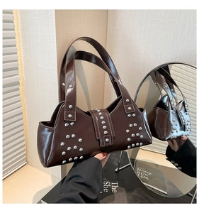 Détail des clous argentés sur le sac à bandoulière punk marron foncé au fini cuir