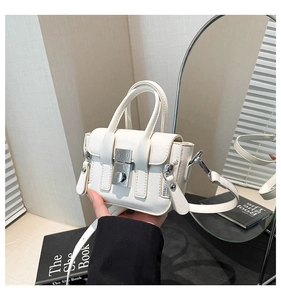 Vue détaillée du mini sac crème avec boucle argentée et texture en cuir raffiné