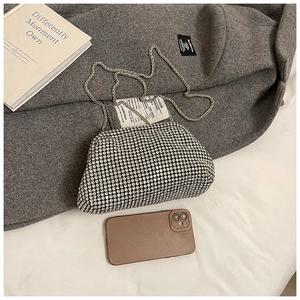 Close-up of sparkling silver rhinestone evening bag on grey wool coat with chain strap