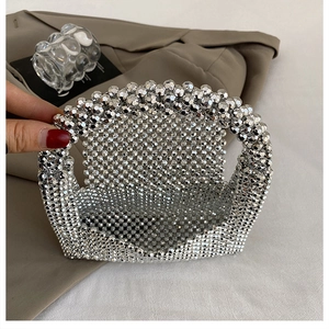 Detail of silver beaded handbag showing intricate handmade weave and metallic texture