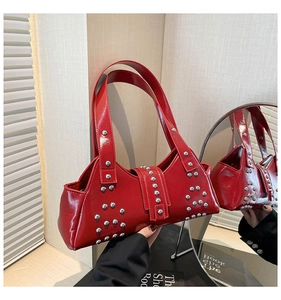 Détail de la surface en cuir verni rouge brillant avec rivets en argent sur le sac à main