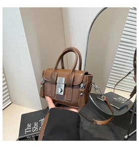 Détail du petit sac bandoulière vintage en cuir marron avec fermoir métallique carré