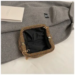 Close-up of golden rhinestone evening bag with black satin lining and chain strap