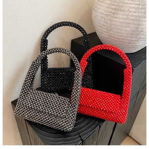 Detailed macro view of beaded handbags in black, silver, and vibrant red colors