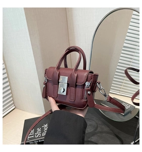Détail d'un mini sac bandoulière bordeaux avec fermoir argenté et texture grainée