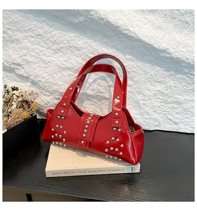 Vue détaillée du sac porté épaule en cuir verni rouge avec rivets punk argentés