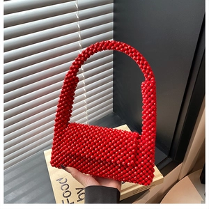 Detailed view of a red beaded handmade handbag with shiny circular woven textures