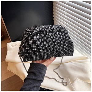 Close-up of black rhinestone evening bag with silver metal chain and flap detail