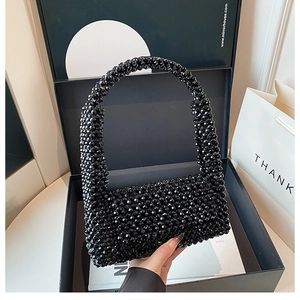 Close-up of black beaded woven handbag showing glossy beads and intricate craftsmanship
