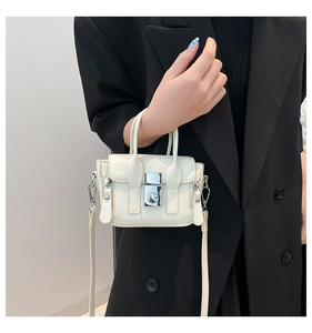 Vue détaillée du mini sac bandoulière blanc en cuir avec boucle argentée et blazer noir