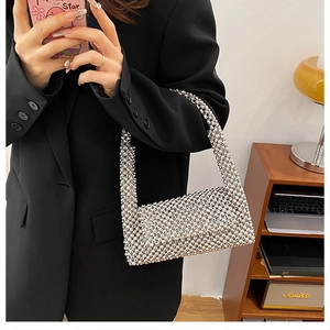 Detailed texture of hand-woven silver beaded handbag with shiny metallic finish