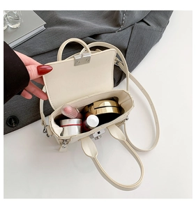 Vue intérieure du mini sac beige montrant le rangement de rouge à lèvres et maquillage