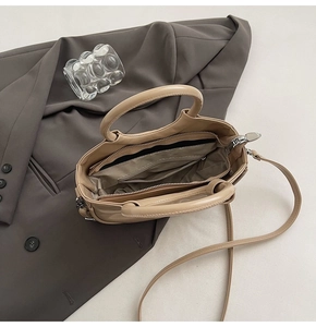 Vue du dessus du sac beige montrant la doublure à chevrons et la poche zippée interne