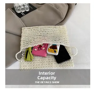 Detail showing internal capacity of handmade cream pearl beaded bag with smartphone and sunglasses