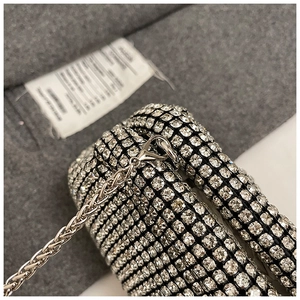 Macro detail of sparkling crystal rhinestones and silver metal chain on evening bag