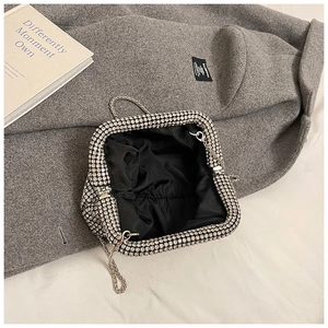 Detailed view of luxury rhinestone evening clutch interior with silver metal chain strap