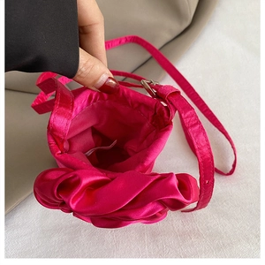 Nahaufnahme der pinken Satin-Handytasche mit weichen Rüschen und Innenetikett