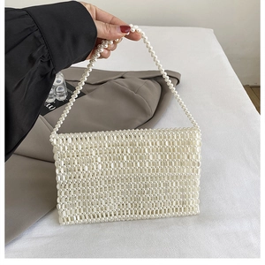 Detail of handmade cream pearl beaded bag showing high-gloss texture and weave pattern