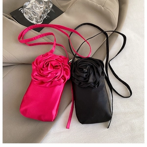 Detail von eleganten Satin-Handytaschen mit großen 3D-Rosen in Schwarz und Rosenrot