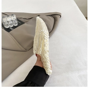 Detailed side view of handmade pearl woven bag showcasing the slim flat structure