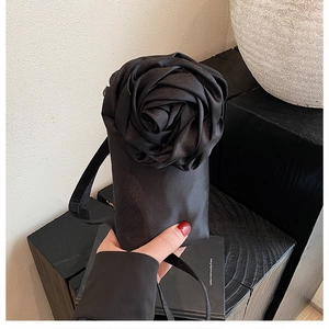 Nahaufnahme der schwarzen Satintasche mit großer 3D-Rose aus Stoff für Damen