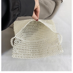 Detail of handmade white pearl beaded bag showing interior space and woven grid structure