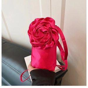 Nahaufnahme von rosafarbenem Satinstoff mit 3D-Blumendesign an der Handyhülle