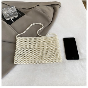 Close-up of handmade pearl beaded handbag showing intricate grid weave and texture