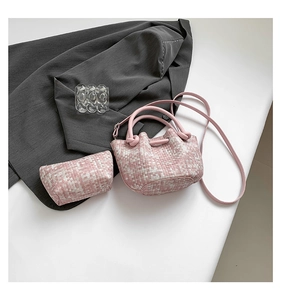 Detail of pink and white tweed bucket bag set with detachable strap on a blazer