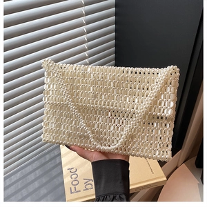 Close-up of handmade white pearl woven handbag with elegant rectangle structure and flap