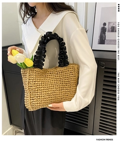 Close-up of handmade straw tote bag with black ruffled handles and decorative tulips