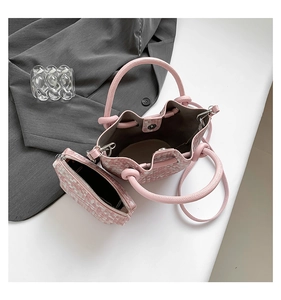 Detailed macro view of pink tweed bucket bag with internal storage and matching mini pouch