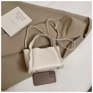 Detail of off-white lychee grain leather handbag with side ruffles and size reference