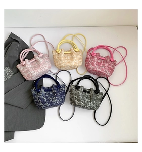 Flat lay of woven mini basket handbags in pink, yellow, navy, and grey with shoulder straps