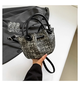 Detail of woven bucket bag featuring black and white pixelated texture and drawstrings