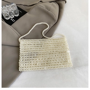 Close-up of handmade white pearl beaded bag with intricate woven hollow structure