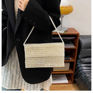 Detail of elegant ivory pearl beaded handbag styled with a classic blazer for a chic look