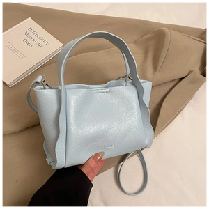 Detail of light blue lychee pattern leather handbag with MUDUO logo and stitching