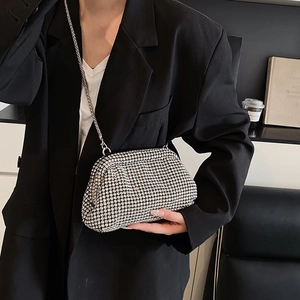 Sparkling silver rhinestone clutch bag with metal chain shown on black suit background