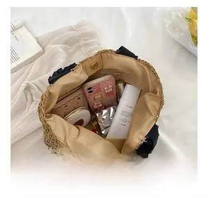 Interior view showing the large capacity and beige lining of the straw woven handbag