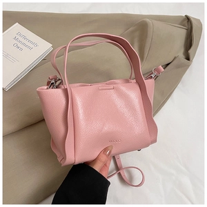 Detail of pink lychee textured leather tote with Muduo logo and adjustable strap