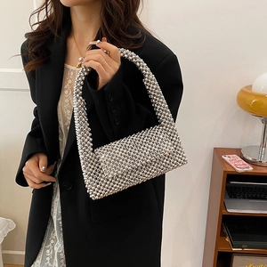 Silver beaded handbag with metallic beads for evening events worn by a model