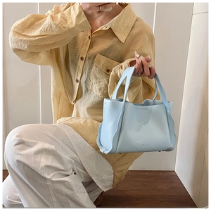 Detail of light blue lychee pattern leather bag with wave pleats and MUUD logo