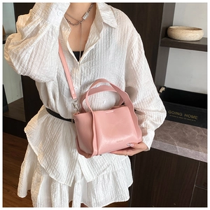 Detail of pink lychee leather handbag with dual handles and detachable shoulder strap