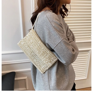 Close-up of handmade white pearl beaded shoulder bag featuring woven bead texture