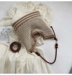 Detailed macro view of woven beach bag with round wooden beads and leather strap