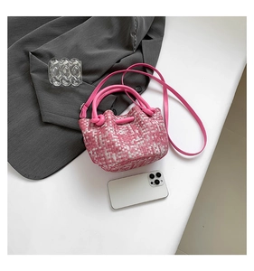 Pink and white tweed mini bucket bag with leather strap and top handle on white background