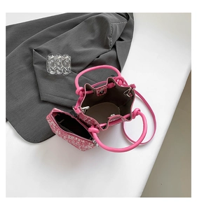 Pink woven bucket bag with matching inner pouch and shoulder strap on white surface